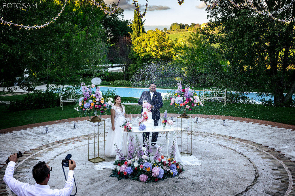 sposi al tavolo del rito con decorazioni floreali durante la cerimonia a villa castellani