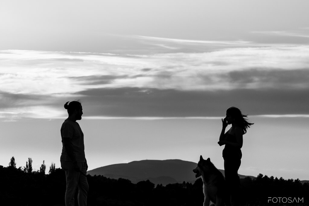 coppia-e-cane-ripresi-in-controluce-durante-una-passeggiata-al-tramonto