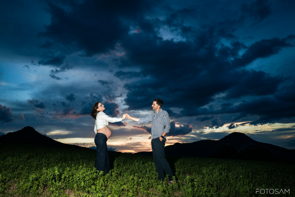 futura-mamma-e-partner-in-un-paesaggio-drammatico-al-tramonto