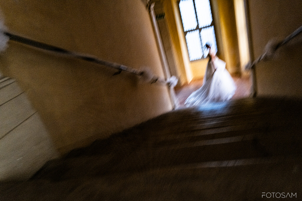 sposa che scende una scala storica a spoleto con mosso creativo, emozione pura del matrimonio a spoleto e fotografie indimenticabili