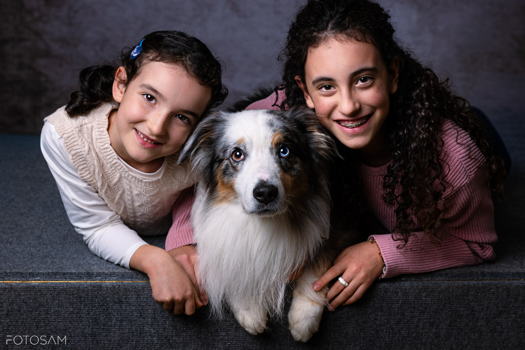 famiglia-con-il-proprio-cane-in-un-ritratto-di-studio-elegante-e-affettuoso