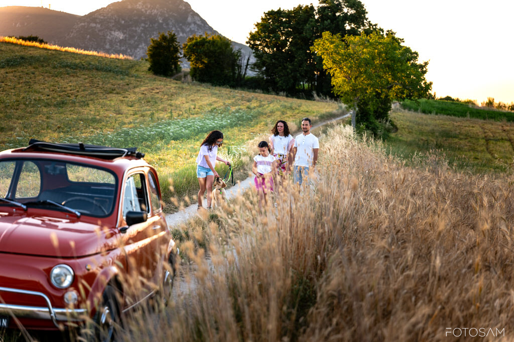 scatto-di-famiglia-con-auto-d-epoca-e-paesaggio-rurale
