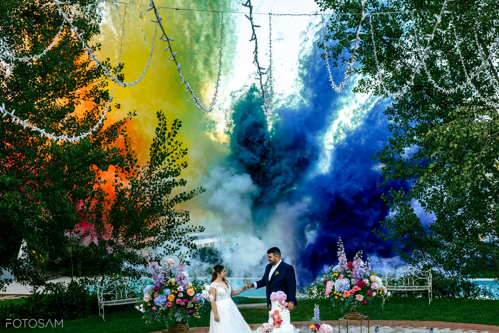 sposi avvolti da fumogeni colorati durante la festa in giardino
