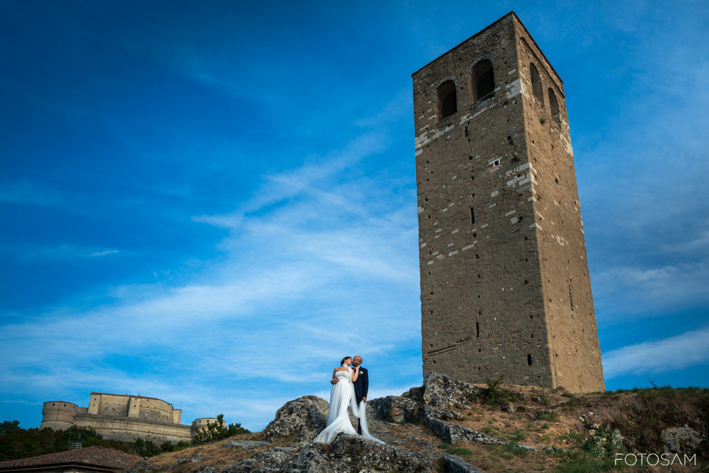 sposi-fotografati-davanti-alla-rocca-di-san-leo-sotto-il-cielo-blu