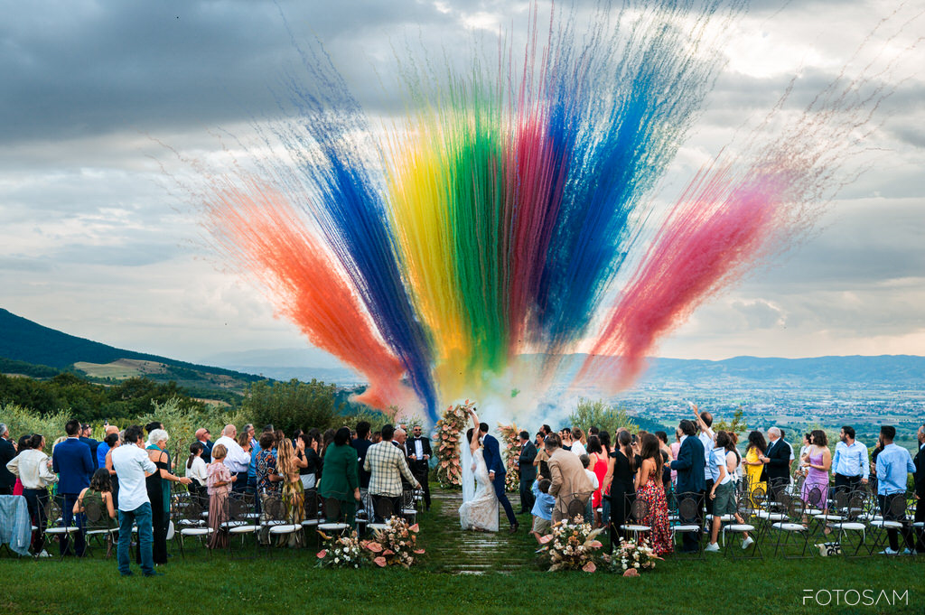 ospiti-che-festeggiano-allaperto-con-una-esplosione-di-colori-e-vista-panoramica-su-assisi