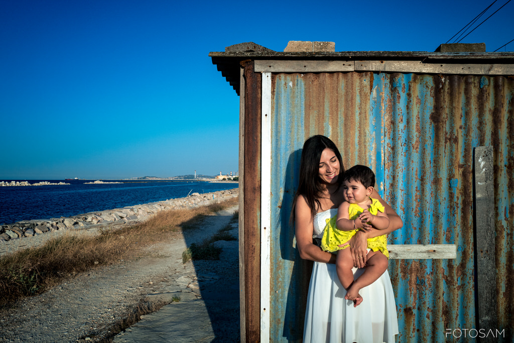 mamma-con-bambina-davanti-a-una-baracca-sul-mare