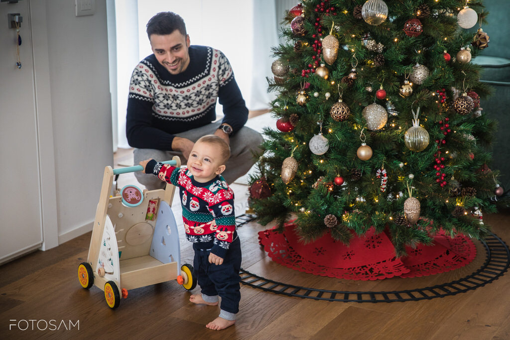 papa-aiuta-bimbo-avvicinarsi-albero-natale-con-i-suoi-primi-passi