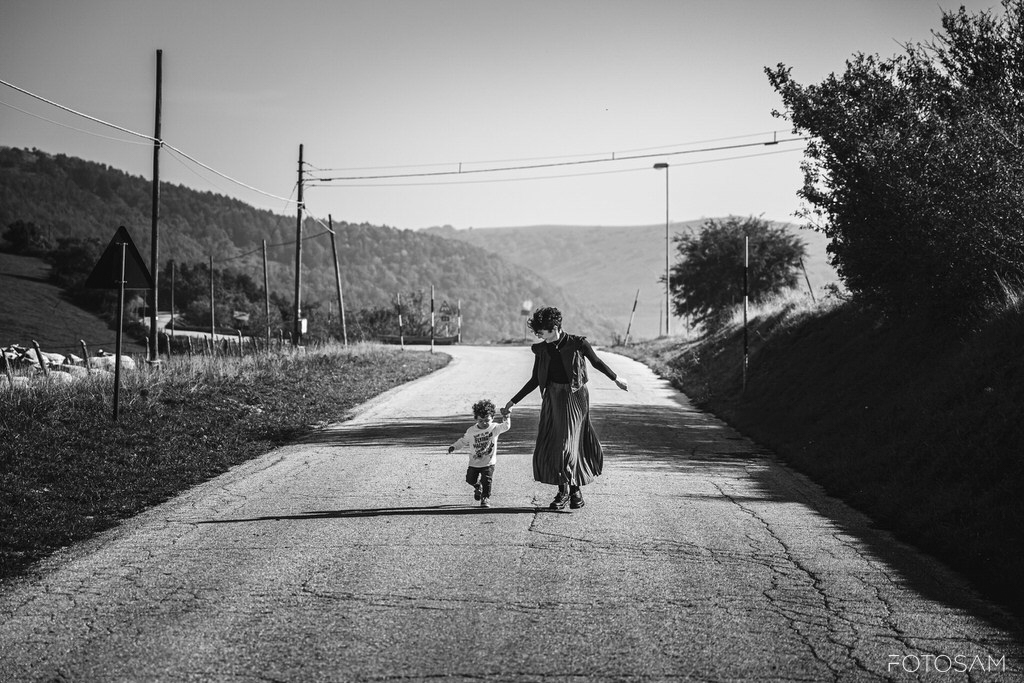mamma-e-figlio-che-camminano-insieme-su-una-strada-in-campagna