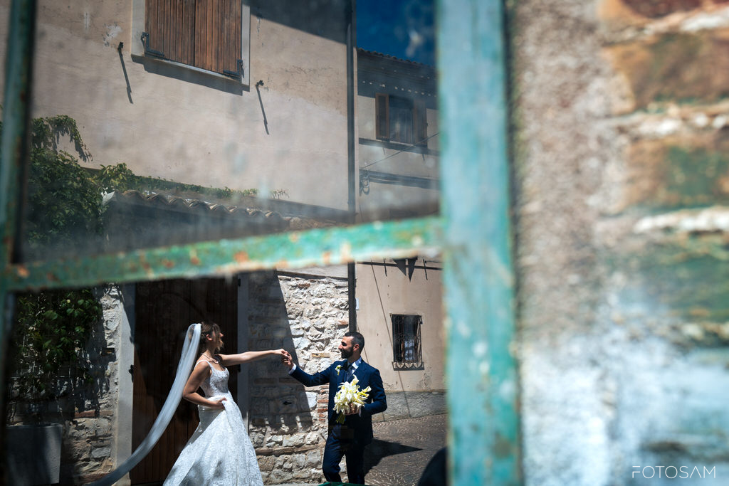 gli-sposi-nel-borgo-ripresi-di-riflesso-in-una-finestra