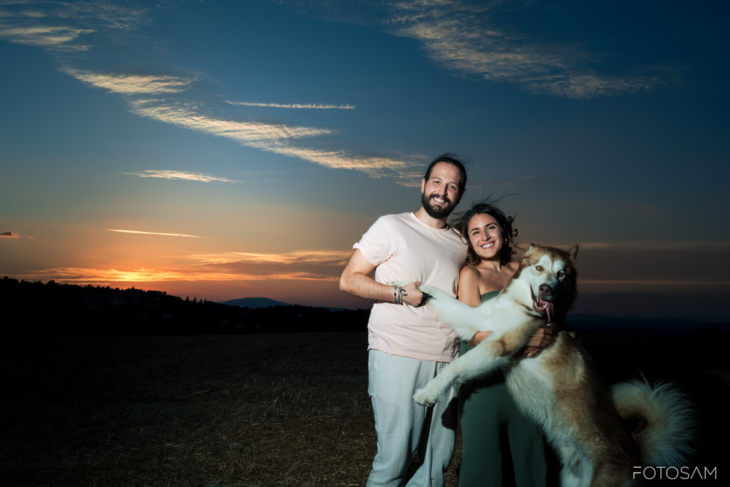 coppia-che-abbraccia-il-cane-con-il-cielo-del-tramonto-sullo-sfondo