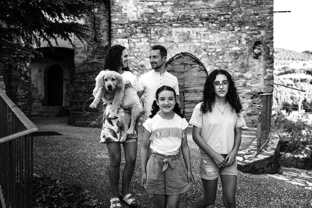 famiglia-con-cane-davanti-al-borgo-storico-nelle-marche
