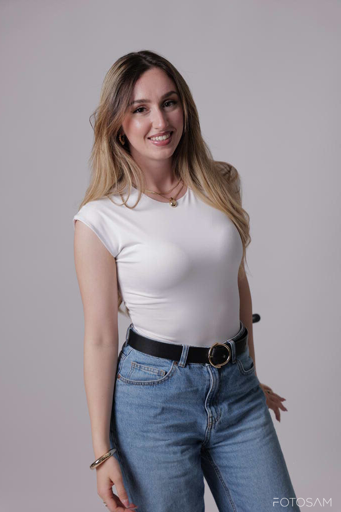 donna-in-piedi-con-maglia-bianca-e-jeans-dal-look-naturale-e-sorridente