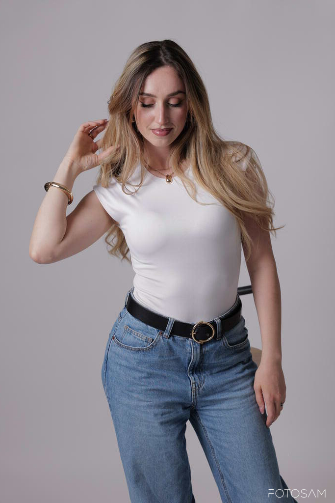 donna-con-maglia-bianca-che-si-sistema-i-capelli-durante-uno-shooting-fotografico