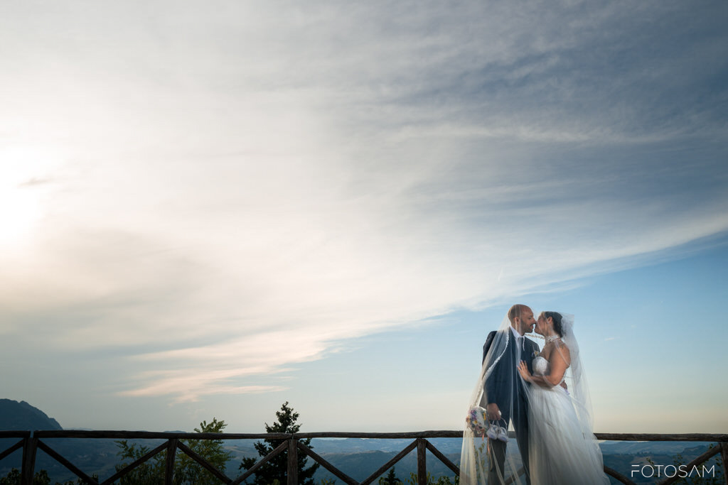 sposi-abbracciati-al-tramonto-con-vista-sulla-valle-di-san-leo