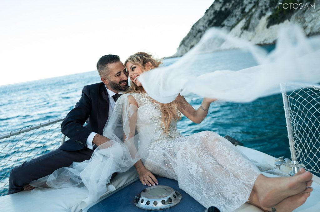 servizio-fotografico-post-matrimonio-in-barca-con-luce-naturale-vento-e-mare-turchese-sullo-sfondo