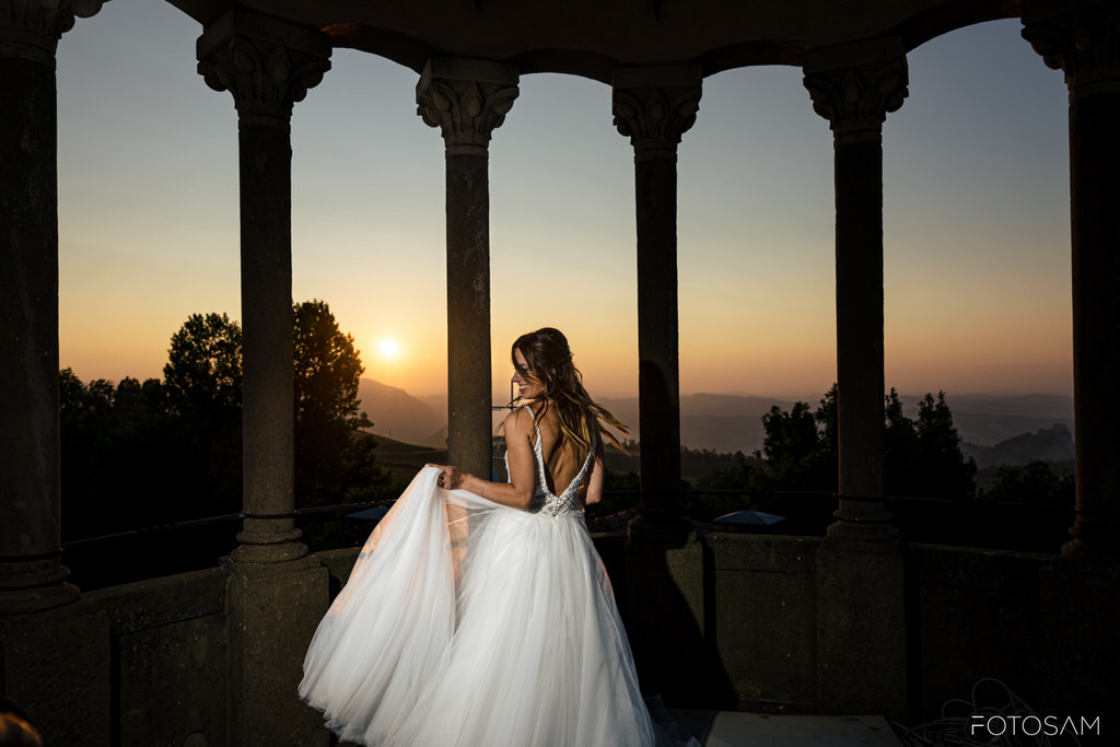 La sposa posa tra le colonne al tramonto, evocando l’eleganza senza tempo dello stile Liberty