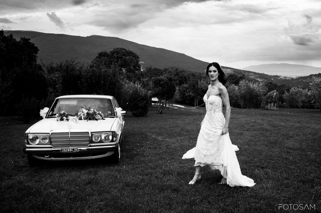 ritratto-della-sposa-accanto-a-una-auto-classica-nel-parco-che-unisce-storia-e-stile-vintage