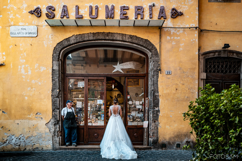 sposa posa davanti a una salumeria storica a spoleto tra vita quotidiana e magia del matrimonio