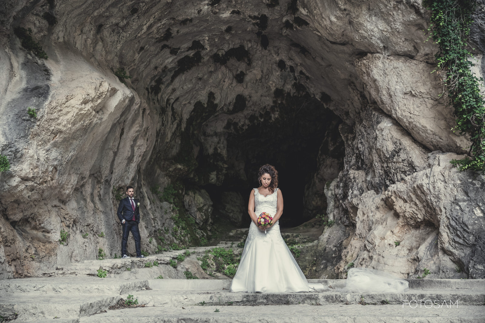 sposa-guarda-il-bouquet-davanti-alla-grotta