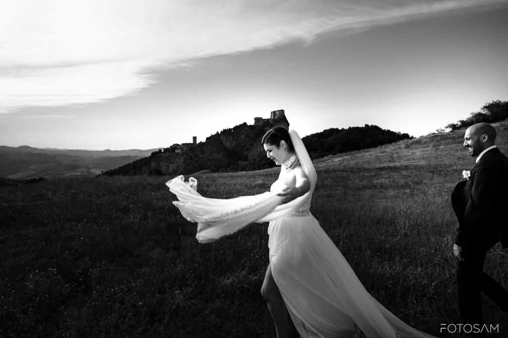 sposi-nel-prato-con-il-velo-della-sposa-mosso-dal-vento