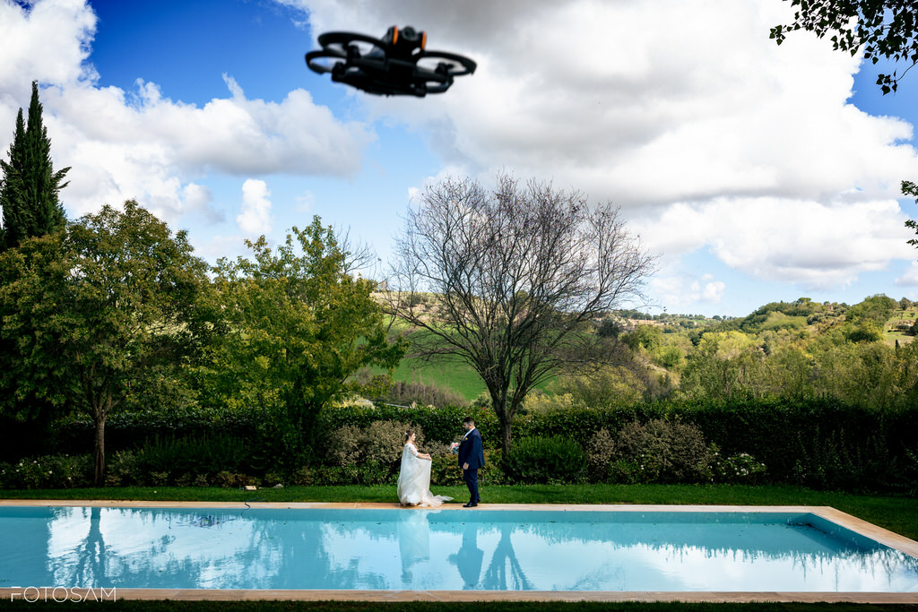 sposi accanto alla piscina ripresi dal drone nel parco della villa castellani