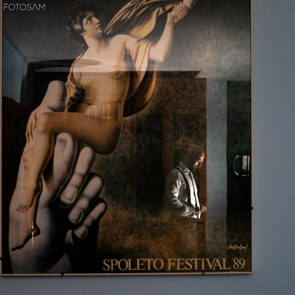sposo riflessa accanto a un poster del spoleto festival, un contrasto artistico tra storia ed emozioni